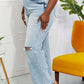 Light wash high waist distressed 90's dad jeans with raw hem and cat's whiskers fading, styled with platform sandals.