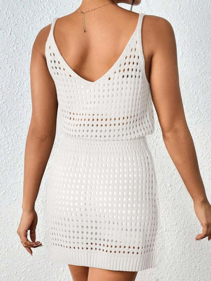 Back view of woman wearing white openwork V-neck sleeveless cover up dress made of stretchy sheer acrylic material.