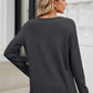 Woman wearing Bella Road Waffle-Knit Notched Long Sleeve T-Shirt in dark gray, showing back view.