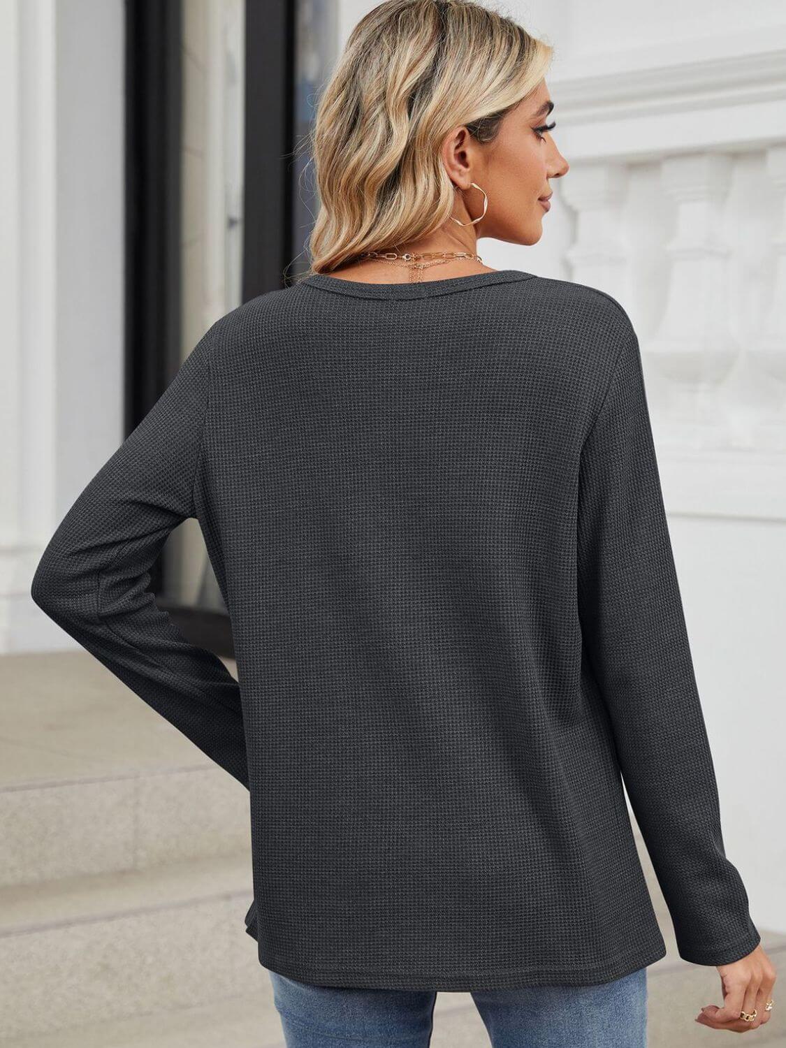 Woman wearing Bella Road Waffle-Knit Notched Long Sleeve T-Shirt in dark gray, showing back view.