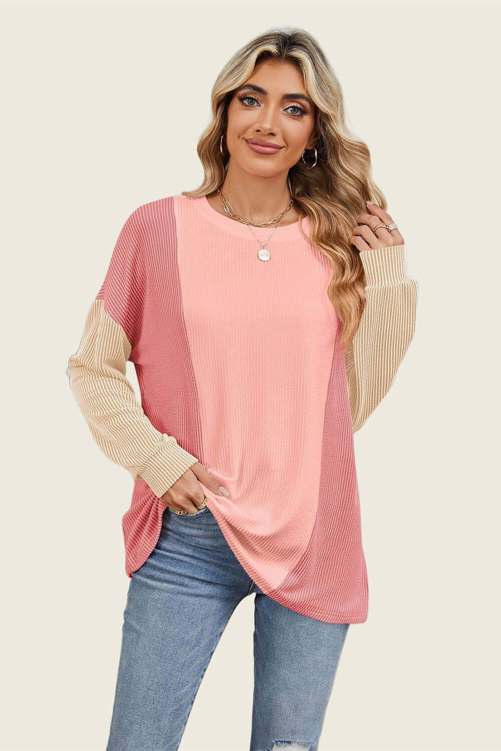 Woman wearing Double Take Texture Contrast long sleeve t-shirt in pink and beige, showcasing trendy layered style.