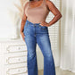 Woman wearing Everyday Full Size Basic Tank Bodysuit in beige paired with high-waisted jeans, standing confidently indoors.