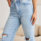 Woman wearing RFM Jeans Tummy Control High Waist Raw Hem Distressed Jeans for a stylish and slimming fit.