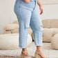 Petite woman wearing Tummy Control High Waist Raw Hem Distressed Jeans by RFM Jeans with tummy control and raw hem details.