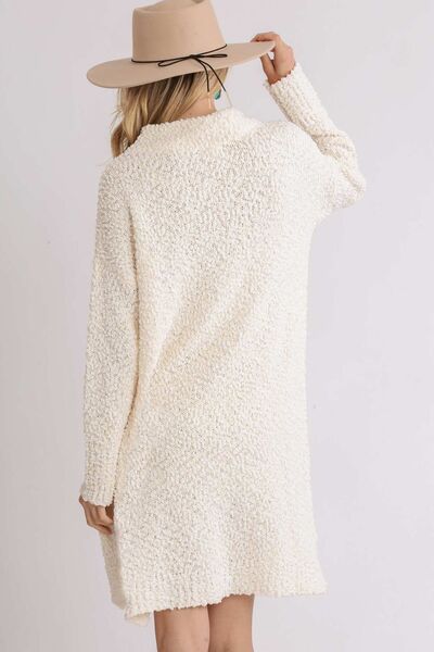 Back view of Umgee high-low boucle sweater dress in cream, showcasing cozy fabric and modern style.