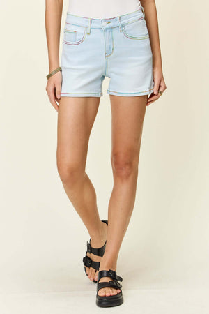 Woman wearing Judy Blue Jeans contrast stitching denim shorts with pockets, showcasing casual summer style.