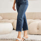 Woman wearing Tummy Control High Waist Raw Hem Distressed RFM Jeans in living room.