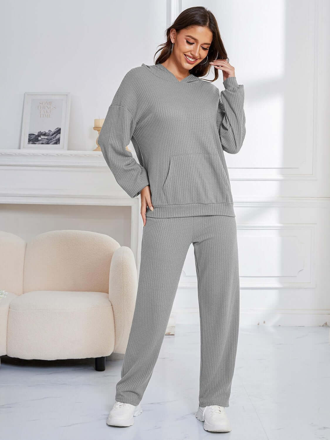 Woman in gray Bella Road hoodie and pants set, cozy and stylish for lounging or errands. Relaxed fit and slightly stretchy fabric.