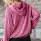 Woman wearing ribbed long sleeve hoodie with kangaroo pocket, showcasing the back view in a stylish urban setting