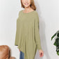 Woman wearing oversized super soft rib layering top with a sharkbite hem and round neck in a relaxed setting.