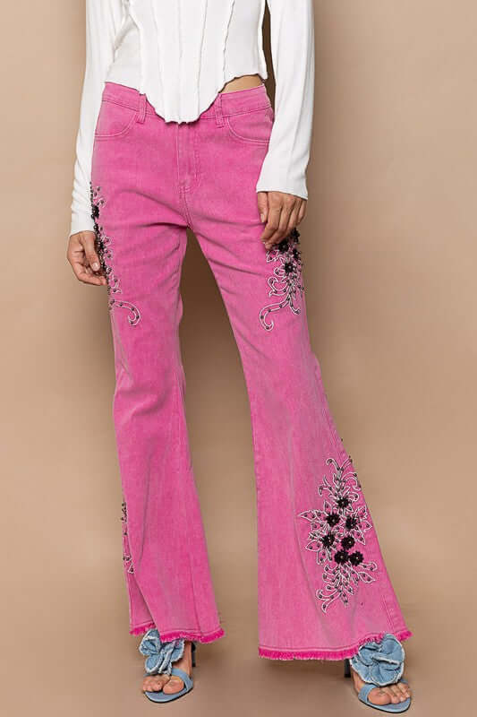 Trendy pink raw hem embroidered flare pants with stylish floral designs, perfect for a bohemian look.