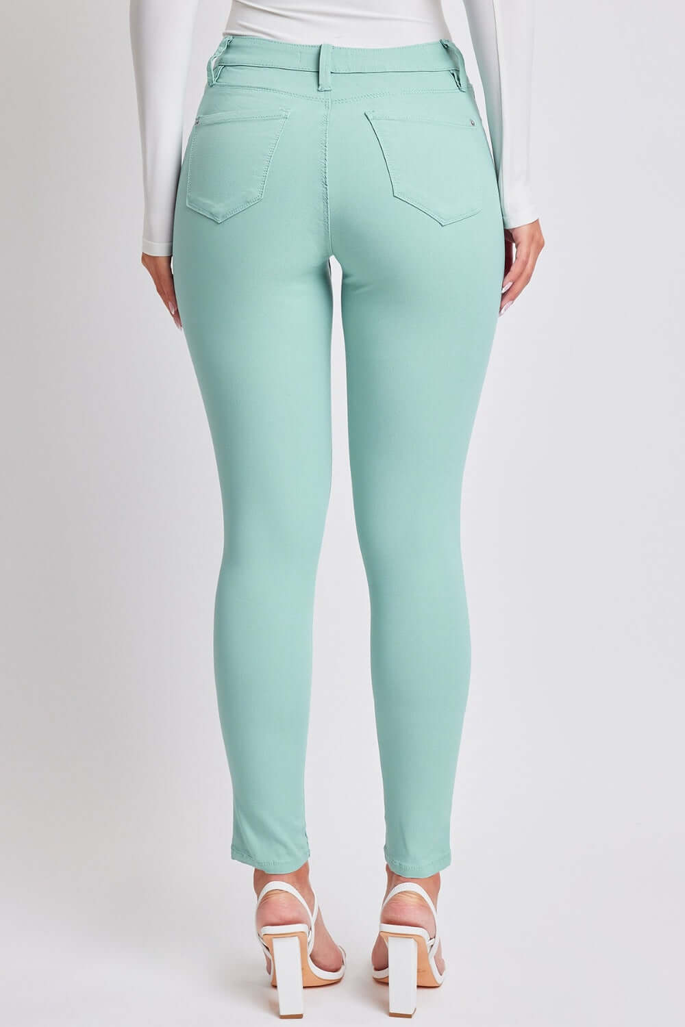 Back view of a model wearing mint green Hyperstretch Mid-Rise Skinny Jeans by YMI Jeans, showcasing a flattering fit and stylish design.