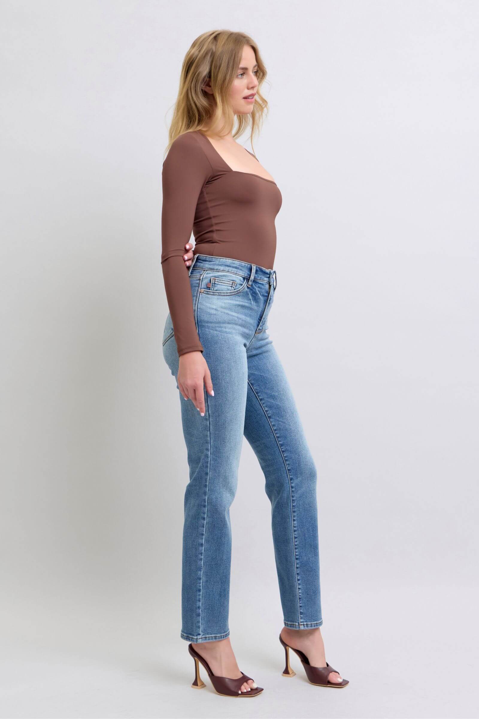 Woman wearing Judy Blue vintage wash thermal straight jeans with pockets and a brown long-sleeve top, showcasing a stylish look.