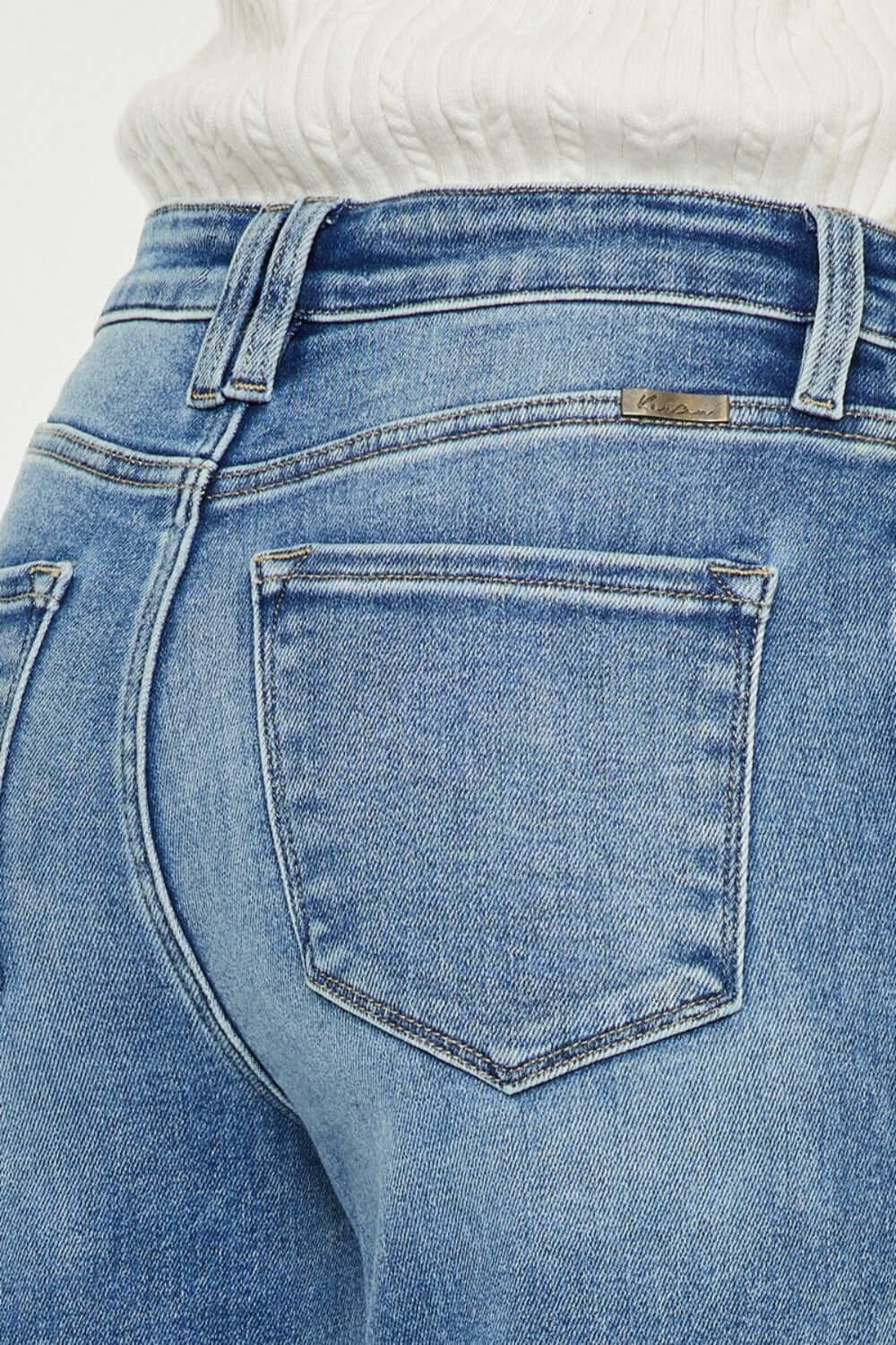 Close-up of Kancan high-rise wide leg jeans back pocket in medium wash, showcasing classic 5-pocket design and denim details.