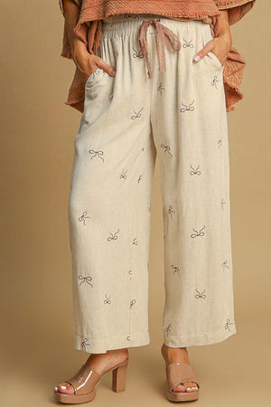 Umgee plus size lace drawstring wide leg pants with embroidered bows, embodying elegance and comfort.