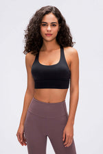 Model showcasing the Millennia Double X Sports Bra in black, paired with high-waisted leggings for a stylish workout look.