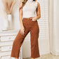 Woman modeling Judy Blue Jeans tummy control garment-dyed wide crop pants in a chic indoor setting.