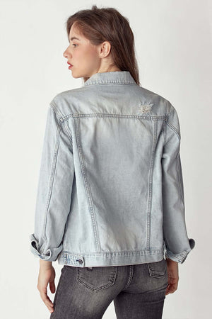 Woman wearing distressed button-up jacket by Risen Jeans, showing back details of the worn-in, rugged design.