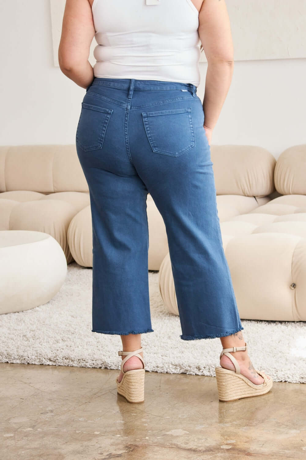 Woman wearing Crop Chloe Full Size Tummy Control High Waist Raw Hem Jeans from RFM Jeans in blue.