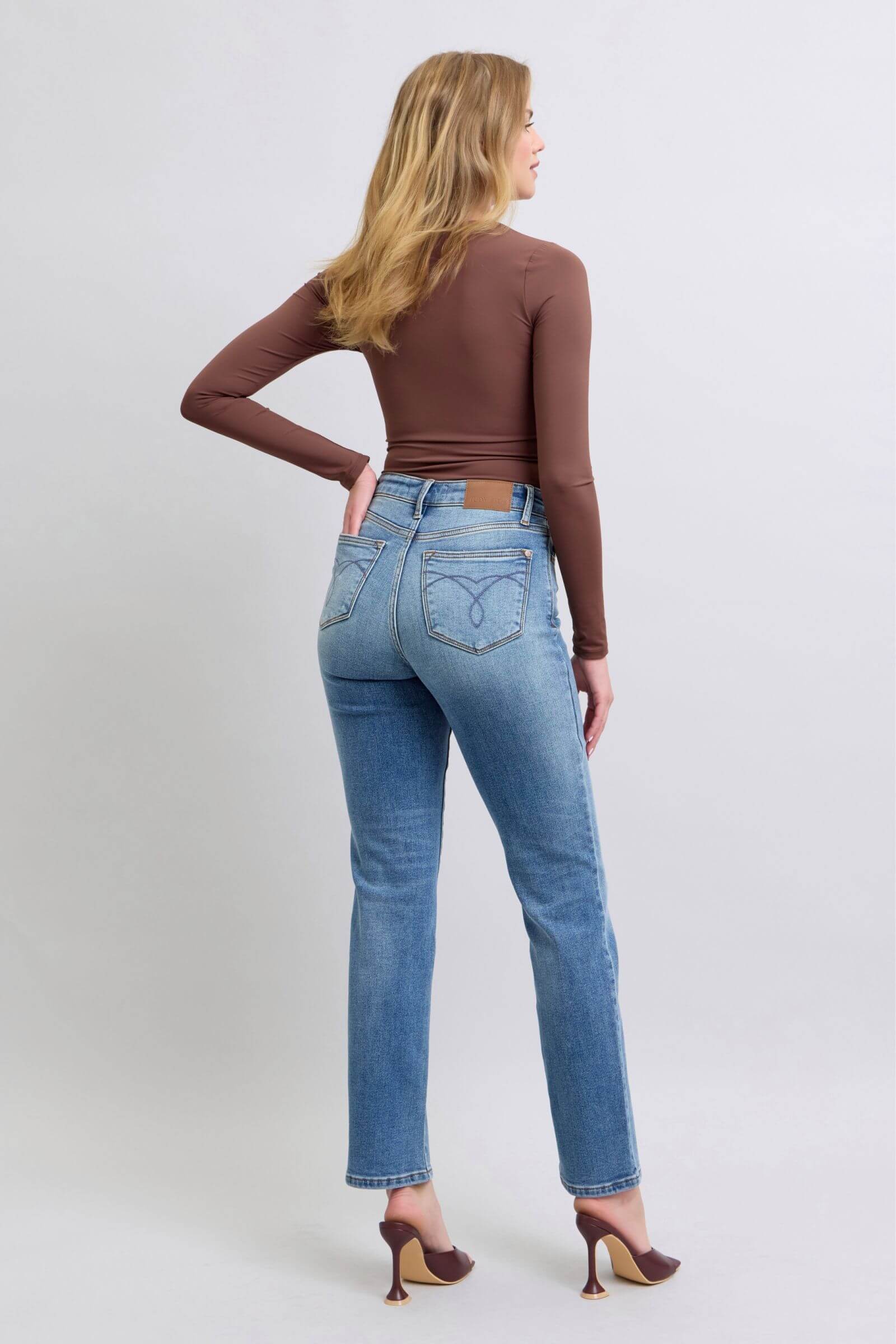 Model in Judy Blue vintage wash thermal straight jeans with pockets and brown long-sleeve top, showcasing a back view.