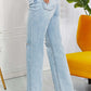 Woman wearing high-waist light wash distressed 90's dad jeans with raw hem standing in stylish room