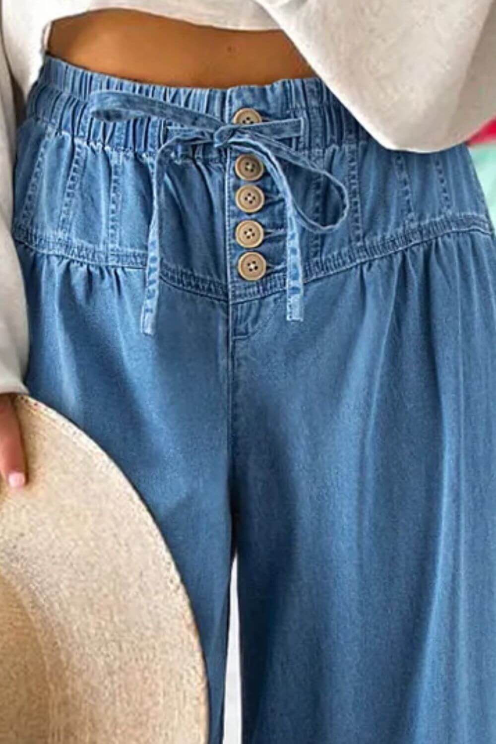 Drawstring elastic waist wide leg jeans in blue denim with button details, 100% cotton, stylish and comfortable fit. Machine wash cold, tumble dry low.