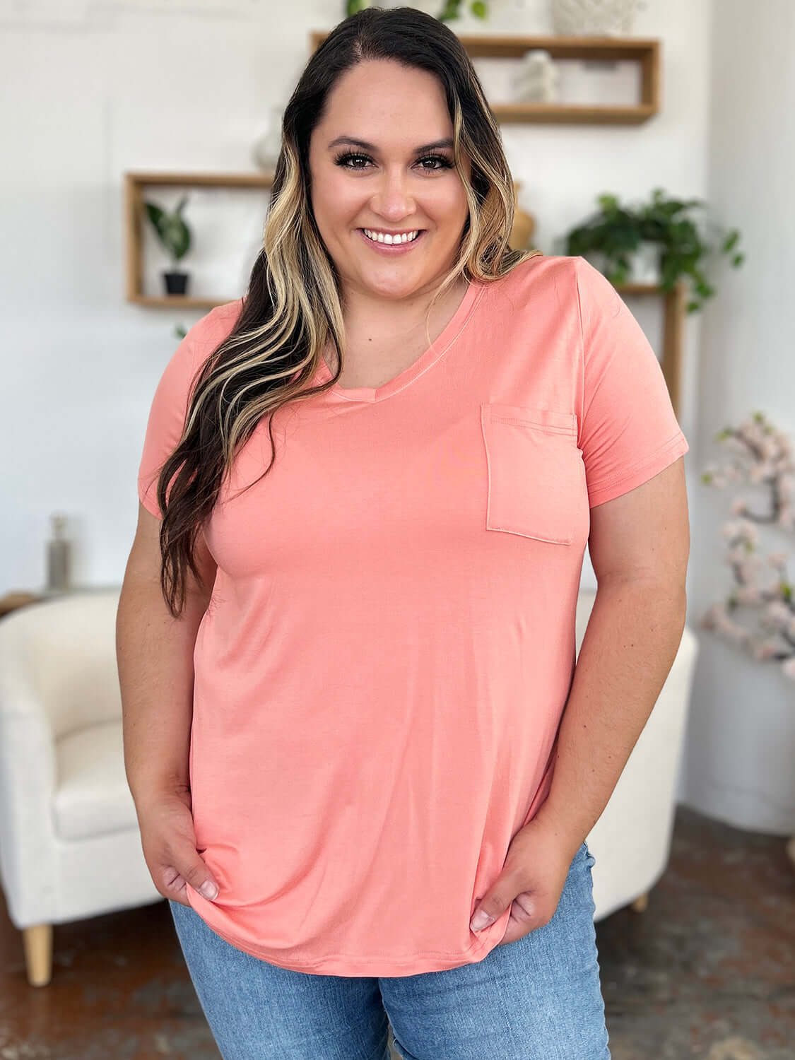 Woman wearing Basic Bae Bamboo V-Neck Short Sleeve T-Shirt in pink, smiling indoors