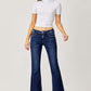 Woman wearing RISEN full size low rise flare jeans with white top