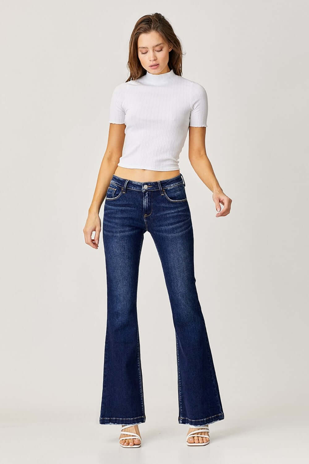 Woman wearing RISEN full size low rise flare jeans with white top