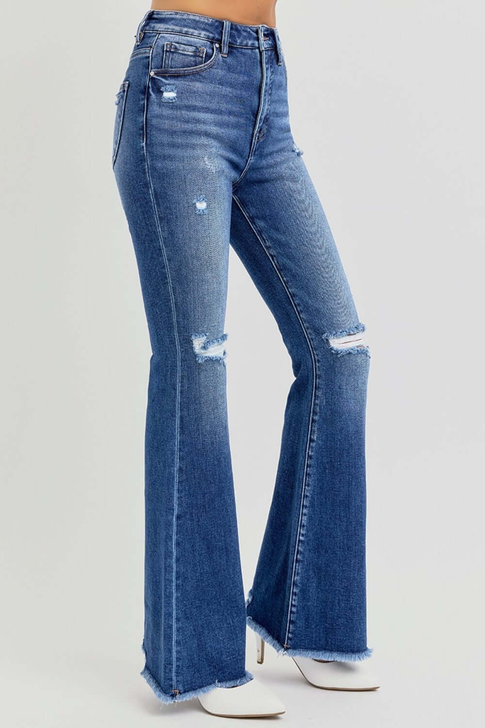 Trendy high rise distressed raw hem flare jeans with retro vibe and modern edge, perfect for stylish outfits.