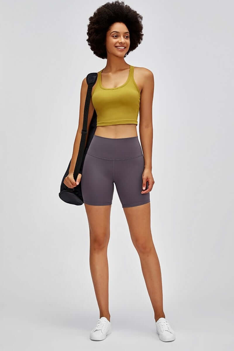 Model wearing Millennia high-waist training shorts and crop top, showcasing comfort and style for gym and casual wear.