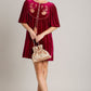 Elegant Umgee embroidered half sleeve velvet mini dress with tassels, paired with a chic handbag for a stylish look.