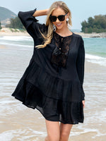 Woman in black Tassel Lace Detail Long Sleeve Cover Up on a beach, wearing sunglasses and smiling.