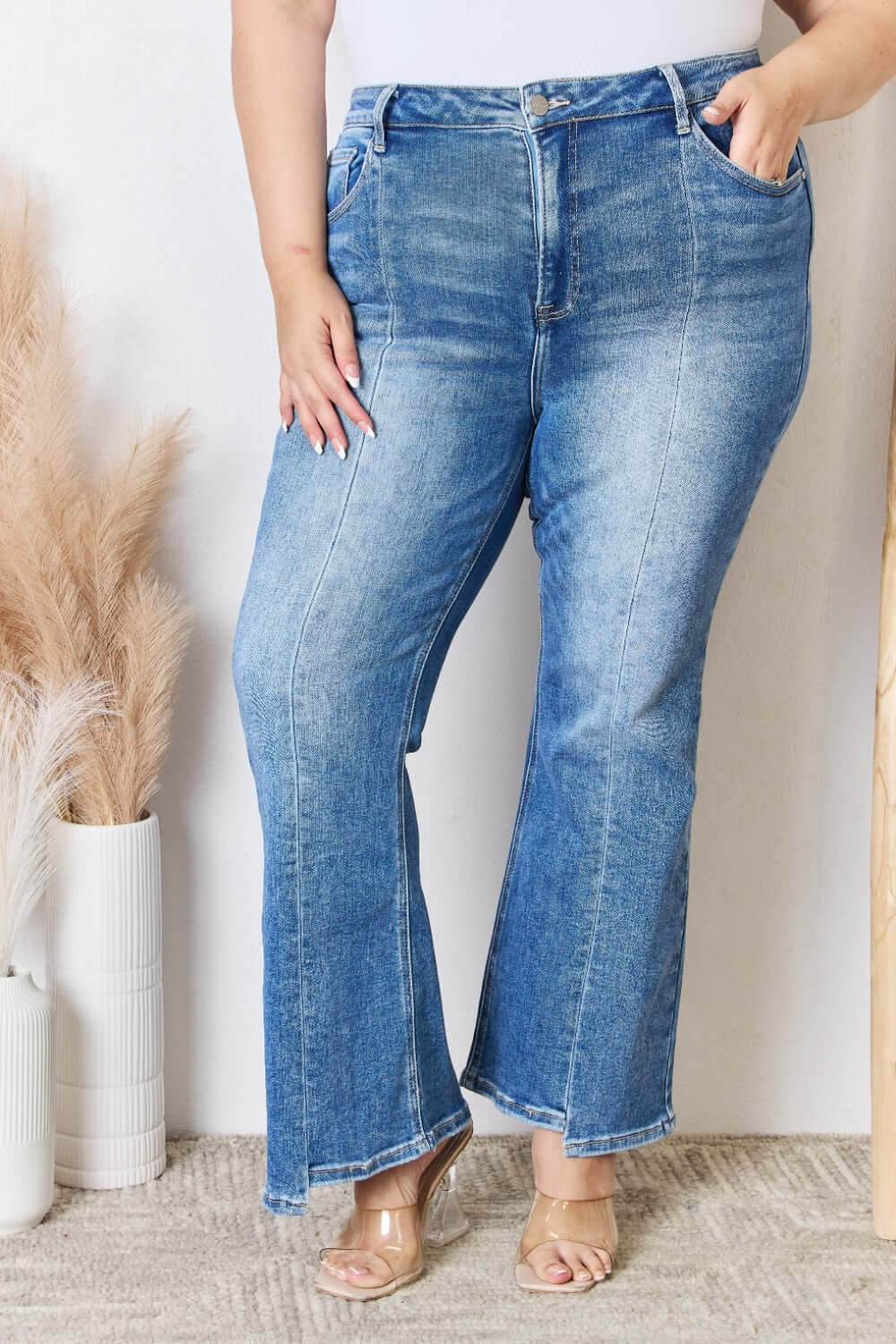 Woman modeling Risen Jeans high rise ankle flare jeans with quality stitching and flattering fit.