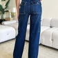 Woman wearing high waist straight cargo jeans from Judy Blue Jeans with back pockets in a modern living room setting.