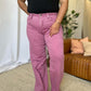 Woman wearing RFM Full Size High Rise Garment Dye Wide Leg Jeans in pink, showcasing the relaxed, wide-leg silhouette and high-waist fit.