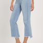 High rise raw edge crop jeans with pockets and slight stretch in light blue denim, paired with clear high heel sandals