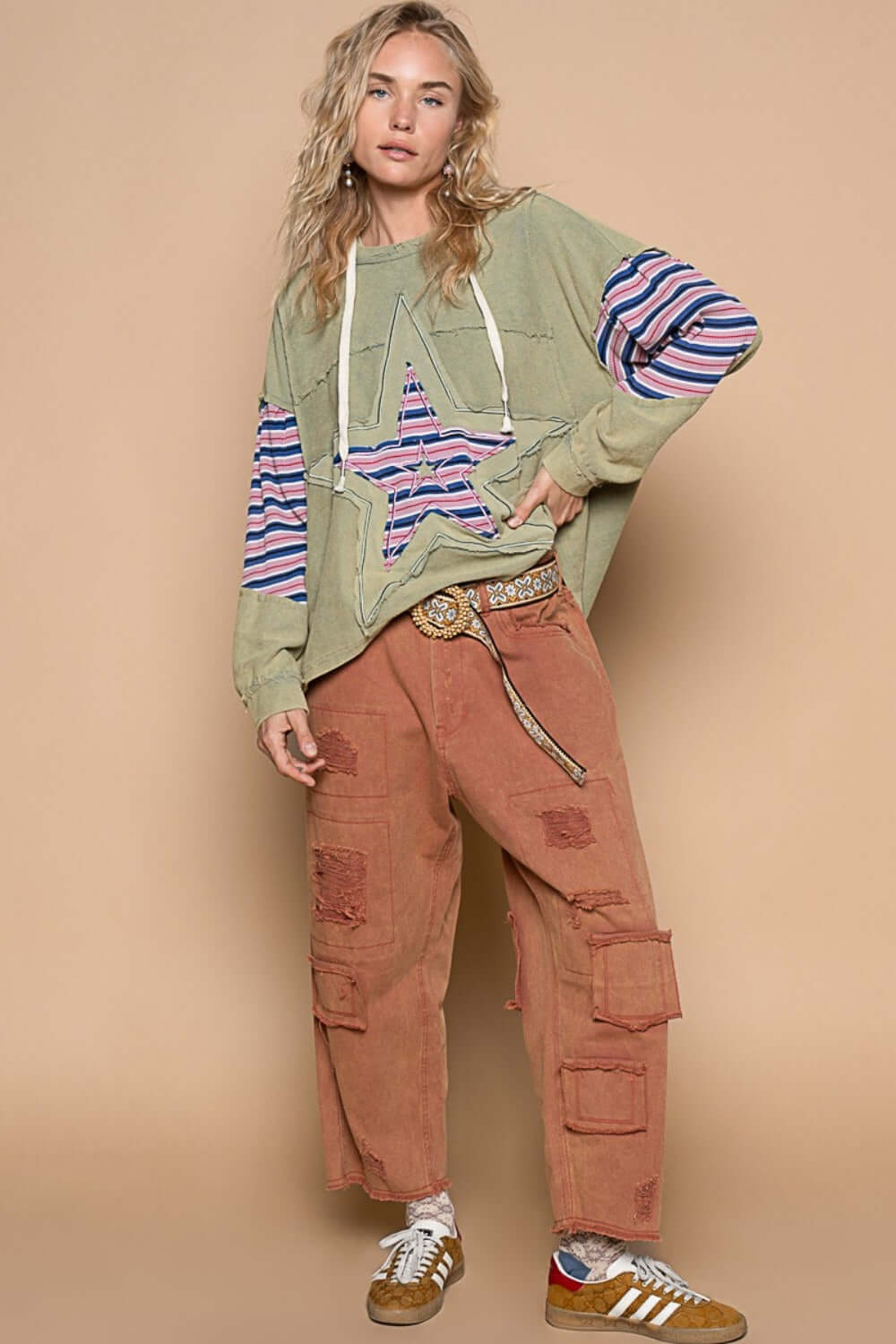 Stylish woman wearing POL Star Patchwork Raw Edge French Terry Hoodie with floral knit and frayed edges, paired with cargo pants.