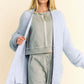 Woman wearing a light blue ribbed hem cardigan over a gray outfit, showcasing a stylish and comfortable layered look.