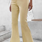 Bella Road Pocketed Raw Hem Flare Jeans in beige with slightly stretchy fabric and a raw hem, styled with white sneakers.