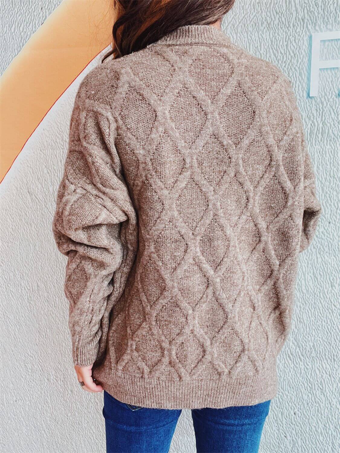 Woman wearing Bella Road Diamond Round Neck Long Sleeve Sweater with unique diamond pattern from back view.