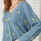 Woman wearing HEYSON full-size floral embroidered cable cardigan, showcasing elegant button-down and cozy knit design.