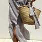 Woman wearing Bella Road Tied Button Up Three-Quarter Sleeve Dress holding a straw tote bag