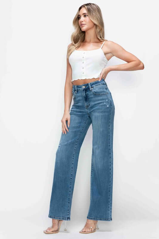 Young woman showcasing bytos full size high rise wide leg jeans with pockets, styled with a trendy white crop top.