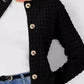 Woman wearing Bella Road button up round neck long sleeve black cardigan over white top and blue jeans