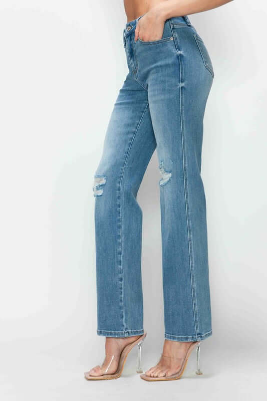 Distressed high rise straight jeans showcasing a flattering fit and edgy rips on a model, perfect for stylish outfits.