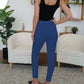 Stylish woman wearing blue FAM-FAM high waist skinny pants in a modern living room, showcasing a chic and versatile outfit.