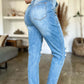 Woman wearing Judy Blue distressed straight jeans with patch pockets and high waist in a casual indoor setting