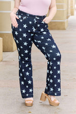 Woman wearing Judy Blue Jeans Janelle Full Size High Waist Star Print Flare Jeans with dark wash and star pattern.