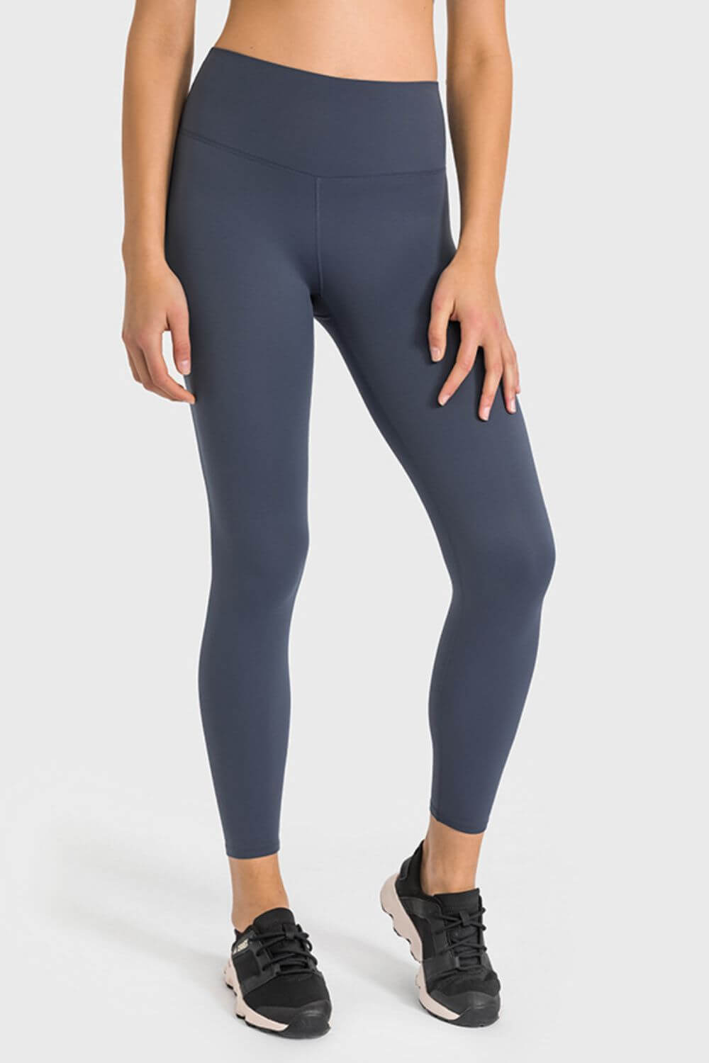 Woman in navy high waist ankle-length yoga leggings, perfect for stylish workouts and yoga sessions.